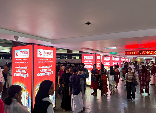 Century Wedding Centre light boxes lining the Calicut bus stand concourse