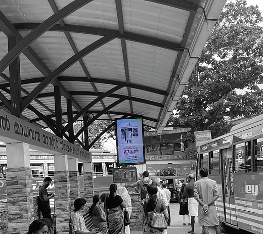 Bus stand display showing live timings alongside advertising
