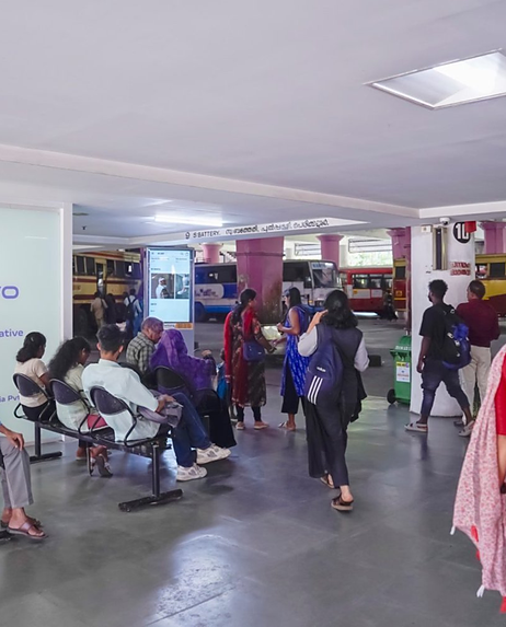Commuters at a KSRTC terminal beside Routerise screens